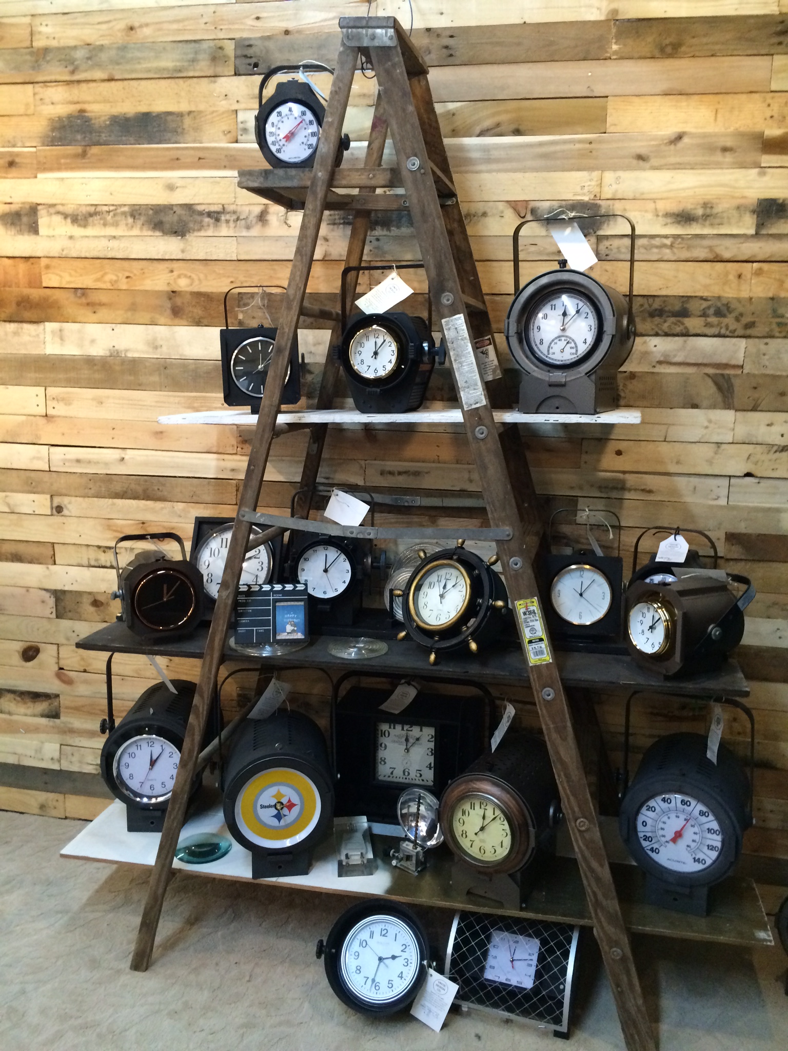 A display of clocks on a ladder